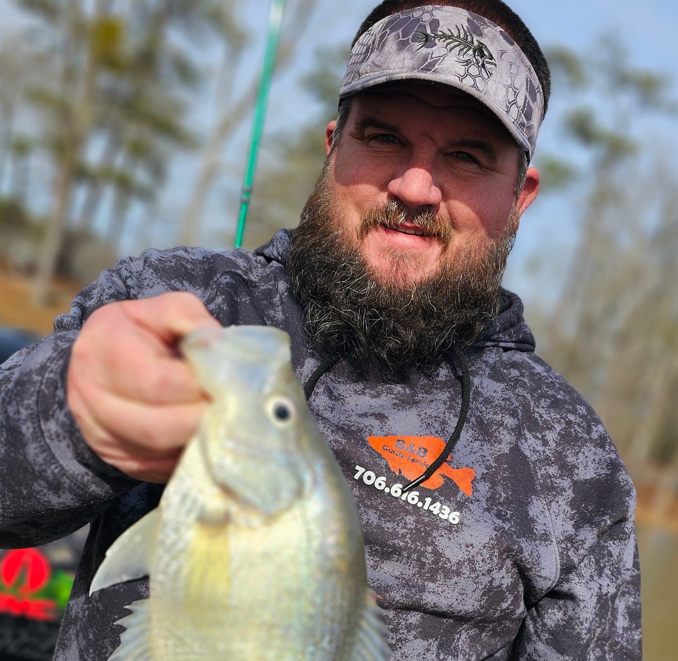 A fishing guide holding up a crappie fish.