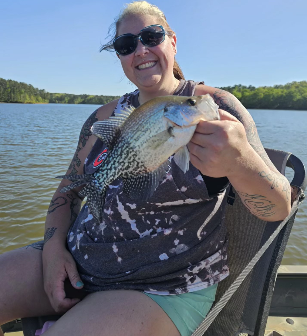 Woman on boat holding up fish